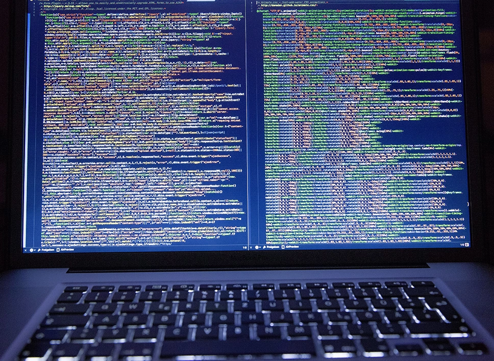 Website Speed Optimization image_a laptop showing a dual window code editor displaying dense walls of code Services